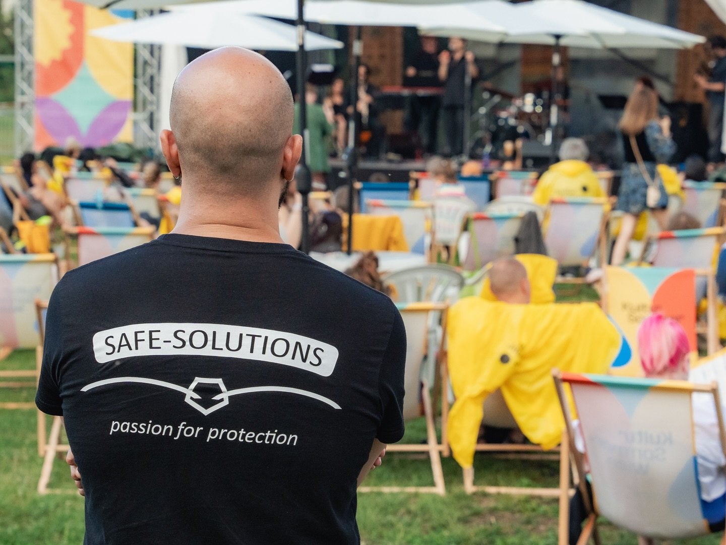 Safe Solutions guard from behind at an outdoor festival with deck chairs