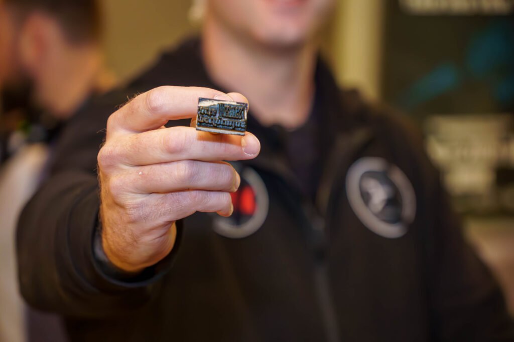 Safe Solutions staff member holding a badge toward the camera